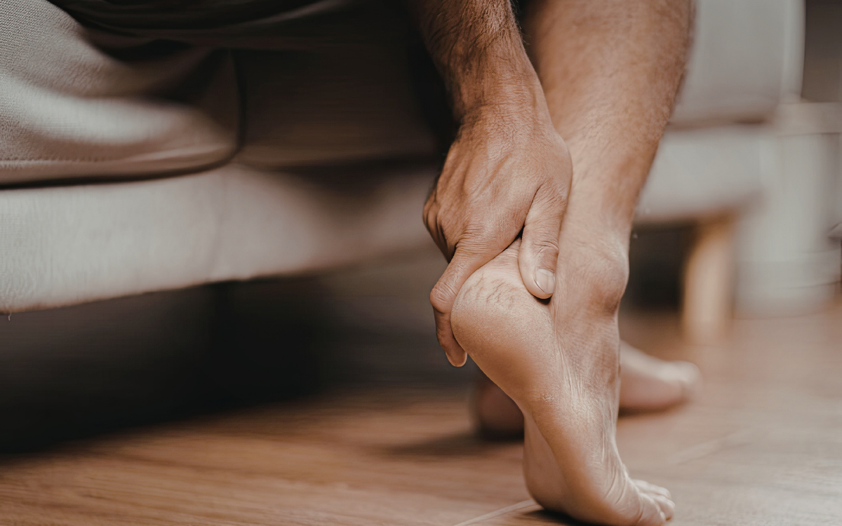 Πόνος στα πόδια από ορθοστασία: Πώς να τον αντιμετωπίσετε αντρική πατούσα, που την ακουμπά ένα αντρικο χερι