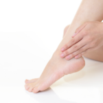 γυναικεία πόδια που τα ακουμπούν χέρια